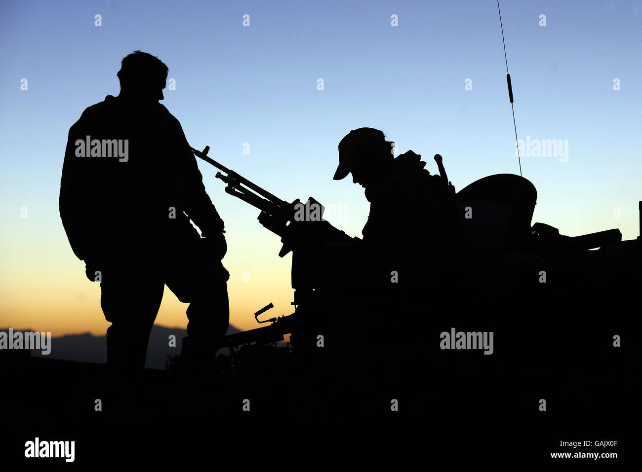 Prince Harry (right) checks the machine gun on his Spartan Armoured