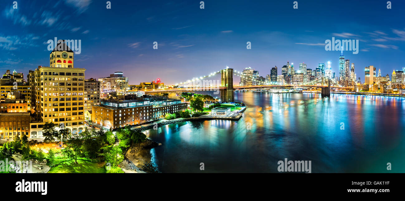 New York City panorama by night. Brooklyn Bridge spans East River linking Manhattan and Brooklyn boroughs Stock Photo