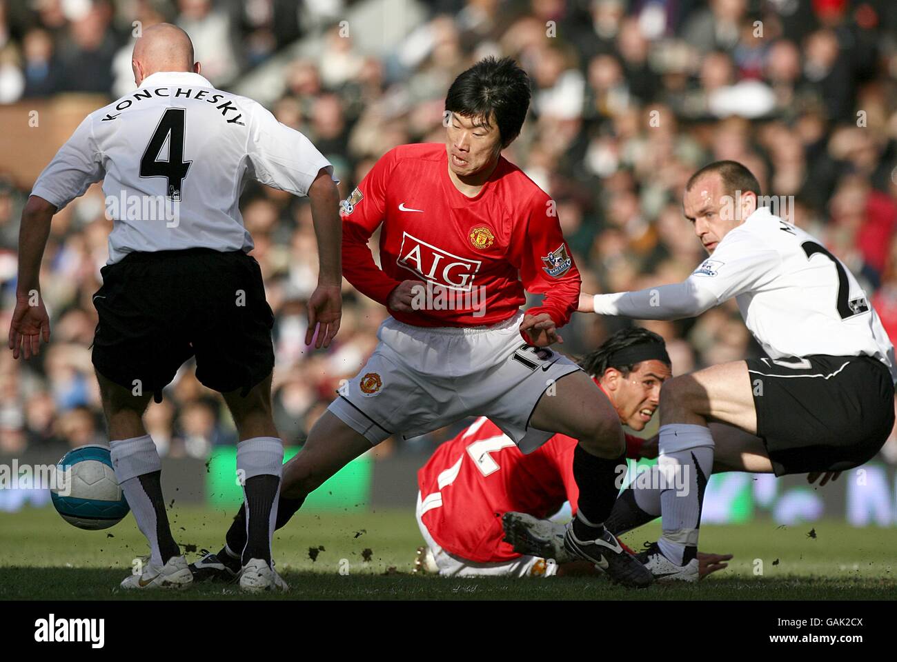 Fulham's Paul Konchesky (l) and Danny Murphy (r) challenge Manchester United's Ji-Sung Park for the ball (c) Stock Photo