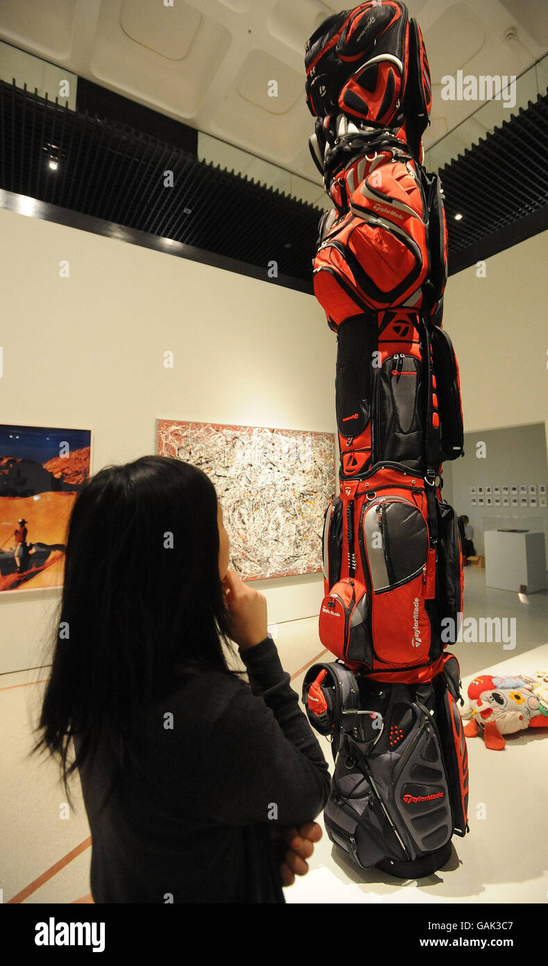 Miss Wing-Sie Chan, a Curatorial Intern at the Barbican Art Gallery in the City of London, studies the Brian Jungen inspired Golf Bags collection, an exhibit in the Martian Museum of Terrestial Art Exhibition. Stock Photo