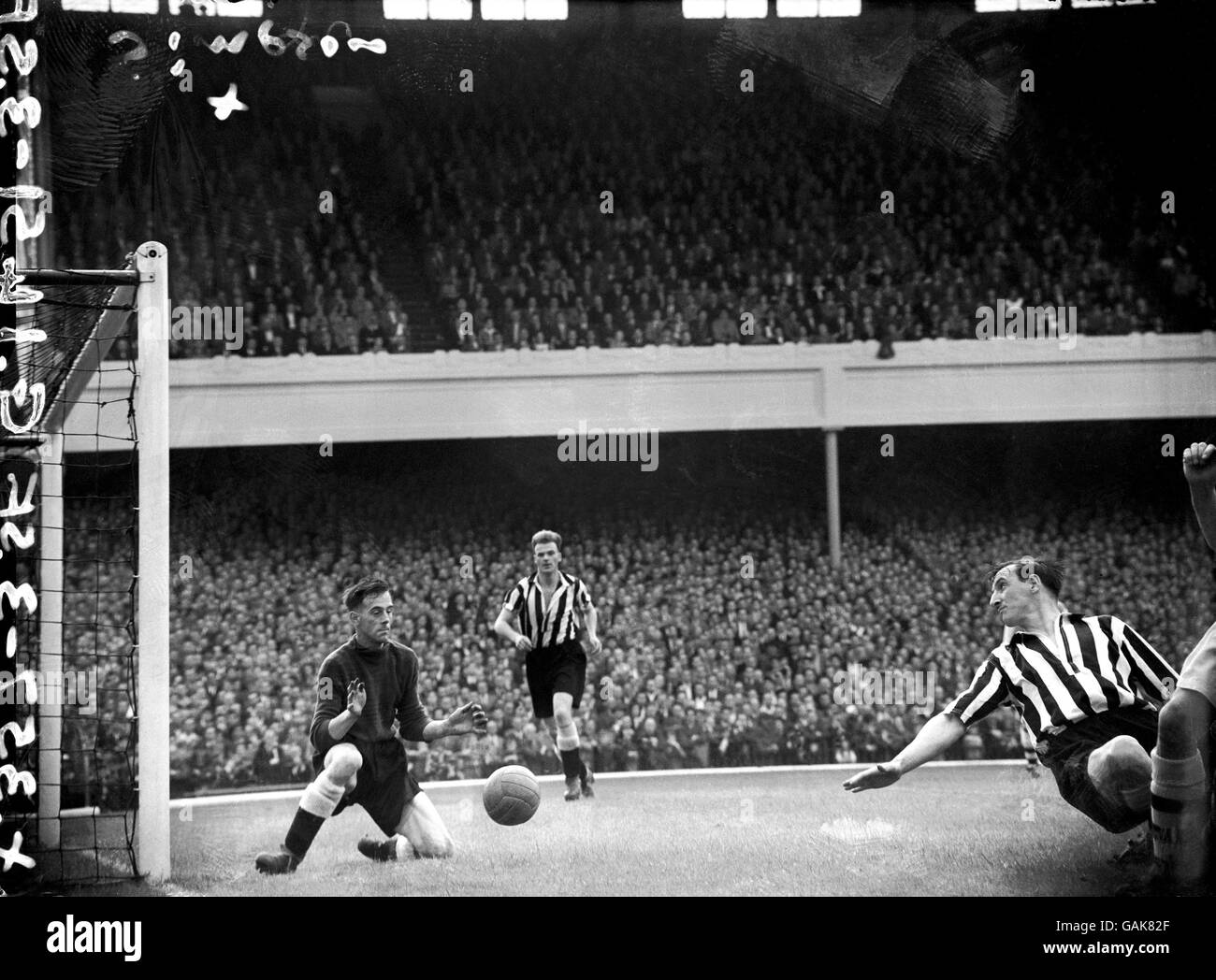 Newcastle United's Alf McMichael (c) and Frank Brennan (r) look on as goalkeeper Ronnie Simpson (l) makes a save at his near post Stock Photo