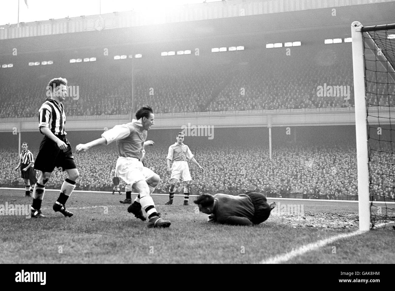 Newcastle United goalkeeper Bob Robinson (r) gathers the ball at the feet of Arsenal's Jimmy Logie (c), watched by teammate Alf McMichael (l) Stock Photo