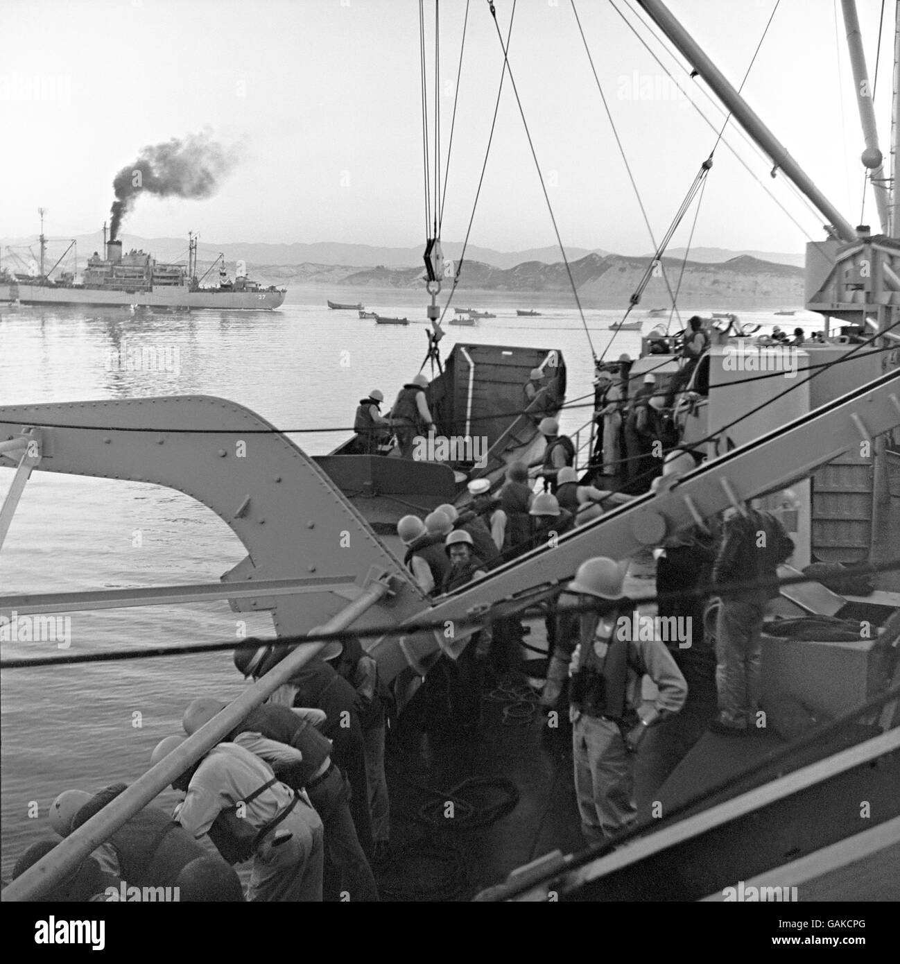 American re-inforcements arriving in Sout-East Korea. Troops and supplies are being landed in small boats from transporters lying off-shore. Stock Photo