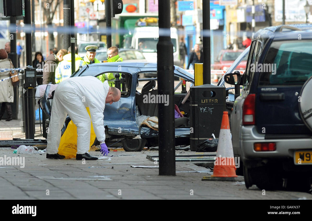A police forensics officer attends the scene in Bethnal Green Road, east London, after a black Mercedes four-wheel drive jeep being pursued by a police car crashed into several cars causing a fatal accident in the early hours of this morning. Stock Photo