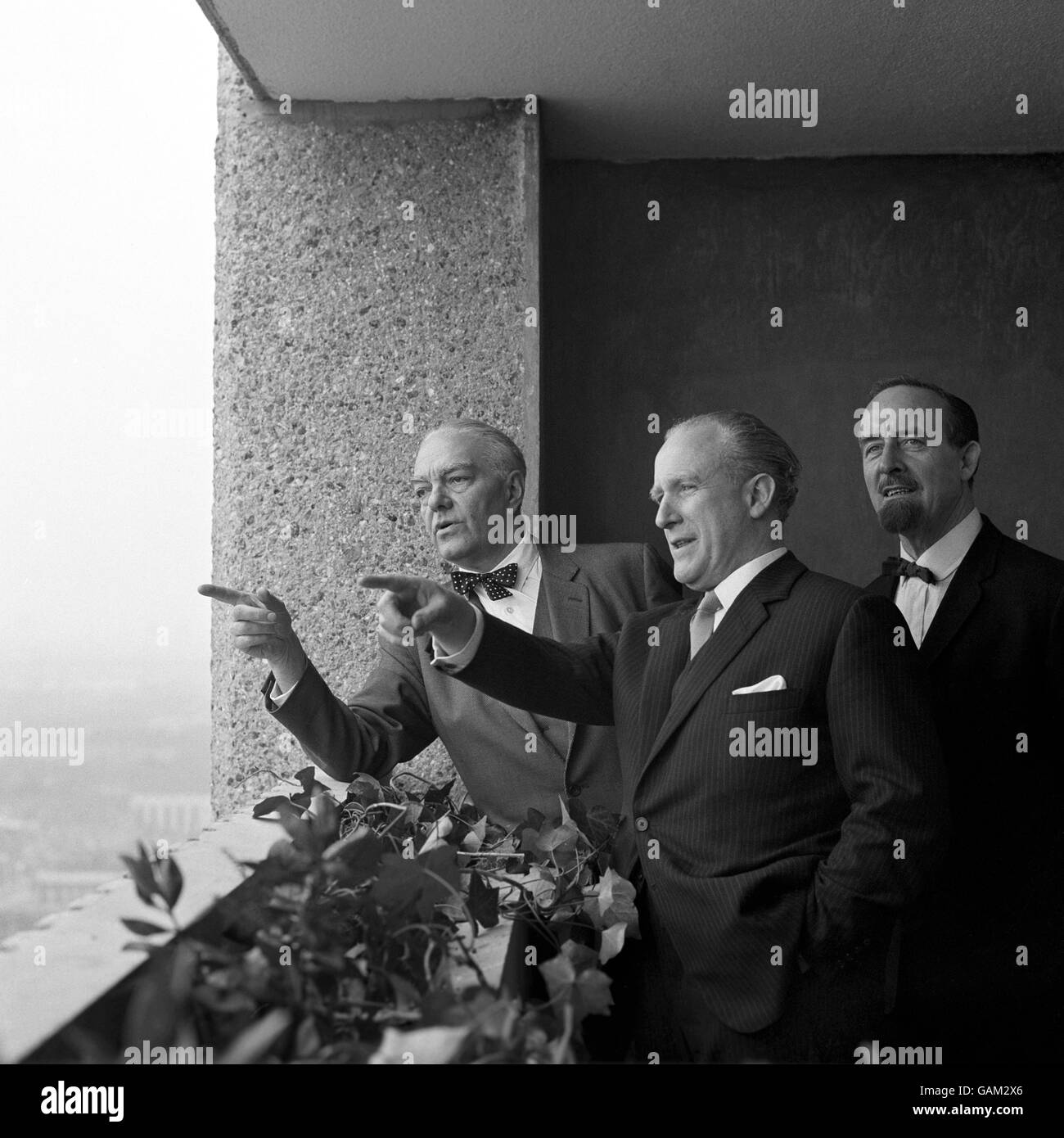 Erno Goldfinger, left, the architect who designed the block and is now living there, shows some guests the view from his flat in the 26 storey block of flats, Balfron Tower, Poplar, London. Left to right, Erno Goldfinger, Desmond Plummer, Leader of the Greater London Council, Horace Cutler, chairman of the Housing Committee. The architect has taken a four roomed flat as a sociological experiment. He will study the living conditions he has produced for GLC tenants and use the experience gained when designing further homes. Stock Photo