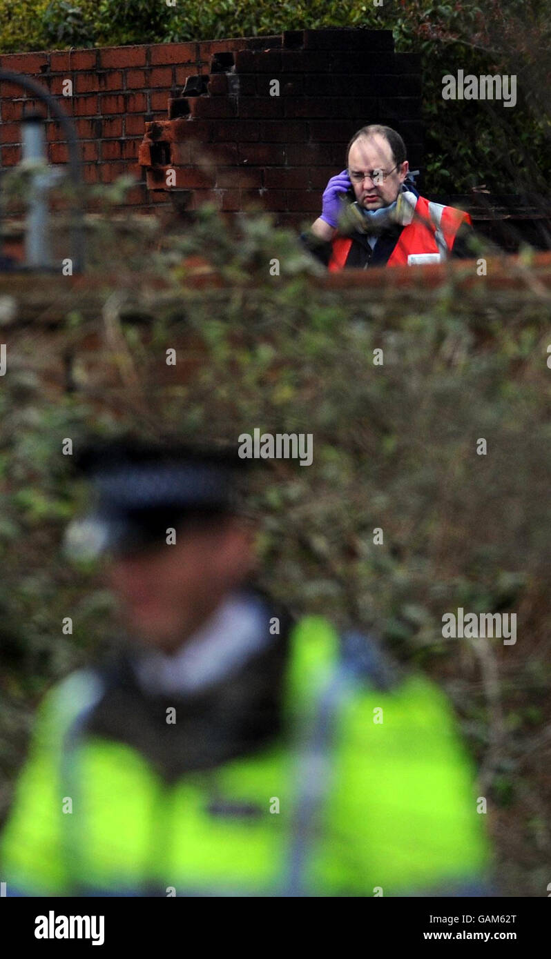 An air accident investigator and police at the site of yesterday's Farnborough air crash where a private aircraft crashed into houses. Stock Photo