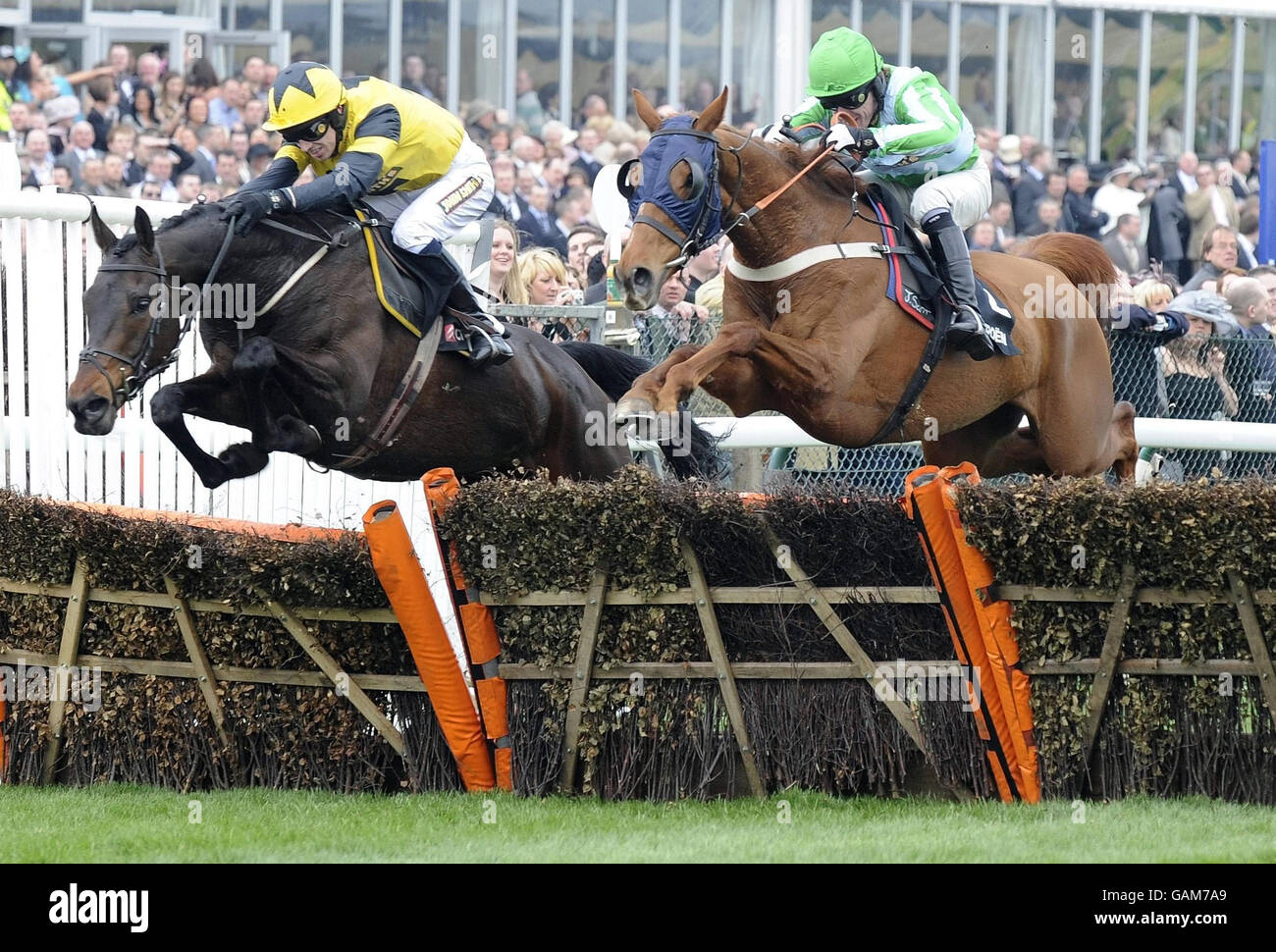 Paddy Brennan and Pettifour (left) jumps alongside Tony McCoy and Gone To Lunch on his way to victory in the Citroen C5 Sefton Novices Hurdle during the Grand National Meeting at Aintree Racecourse, Liverpool. Stock Photo