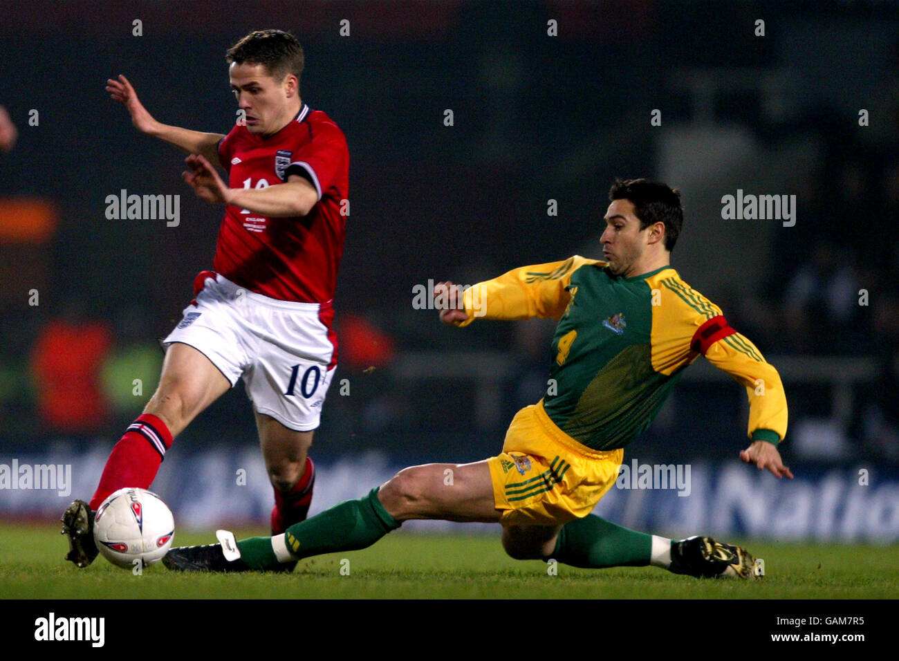 England's Michael Owen is tackled by Australia's Paul Okon Stock Photo