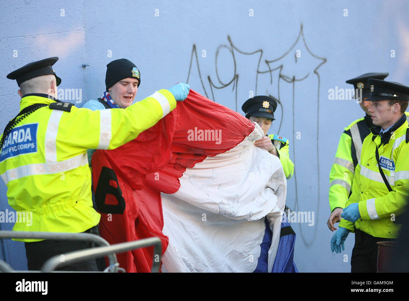 A flag of a Linfield fan being searched before trouble flared amongst supporters at the Linfield FC versus St Patrick's League of Ireland match in Dublin. Stock Photo