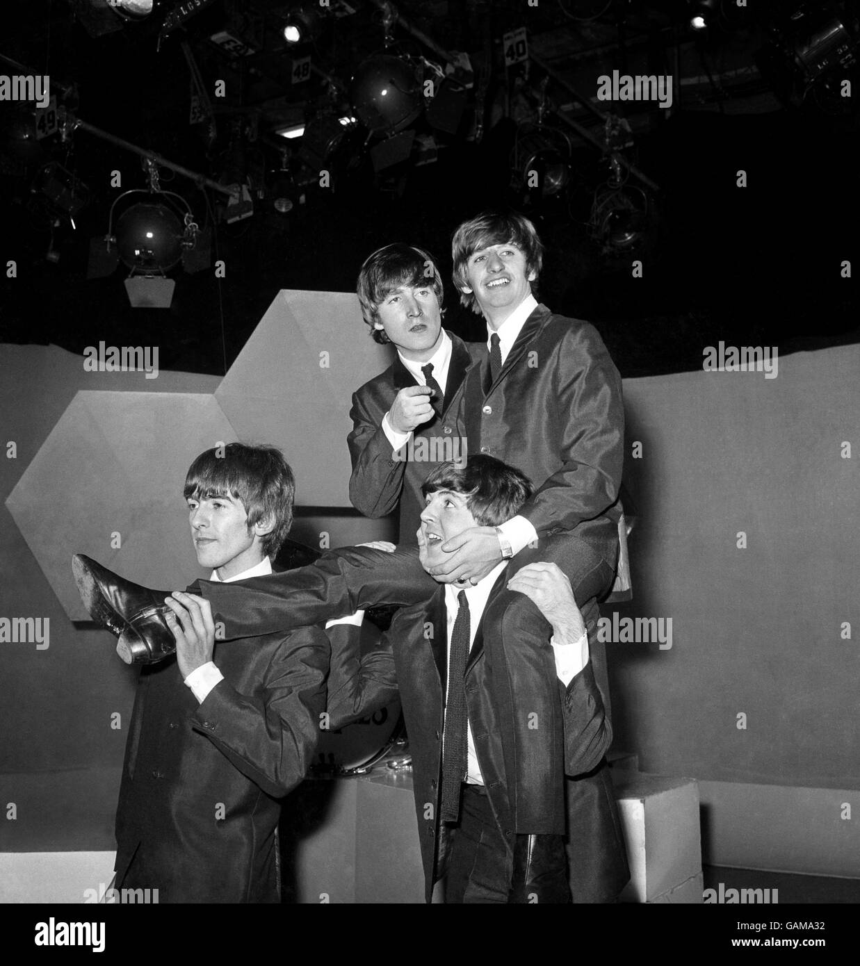Beatles drummer Ringo Starr on the shoulders of Paul McCartney at the BBC's Lime Grove studios on his 24th birthday. Other Beatles are, left to right, George Harrison and John Lennon. Stock Photo