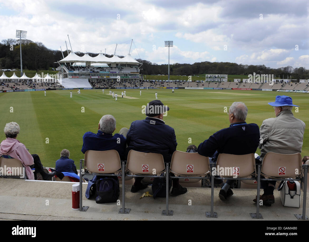 Spectators sit in the grandstand watching Hampshire v Sussex during the LV County Championship Division One match at The Rose Bowl, Southampton. Stock Photo