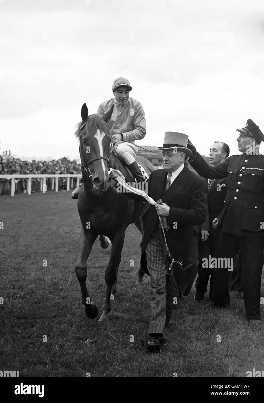 'Galcador', owned by M. Marcel Boussac and ridden by Rae Johnston, is led by his owner into the winners enclosure. Stock Photo