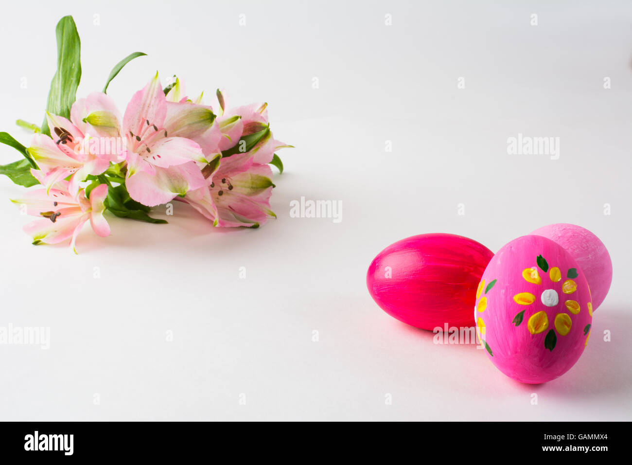 Pink Easter eggs with floral design and pink flowers on a white ...