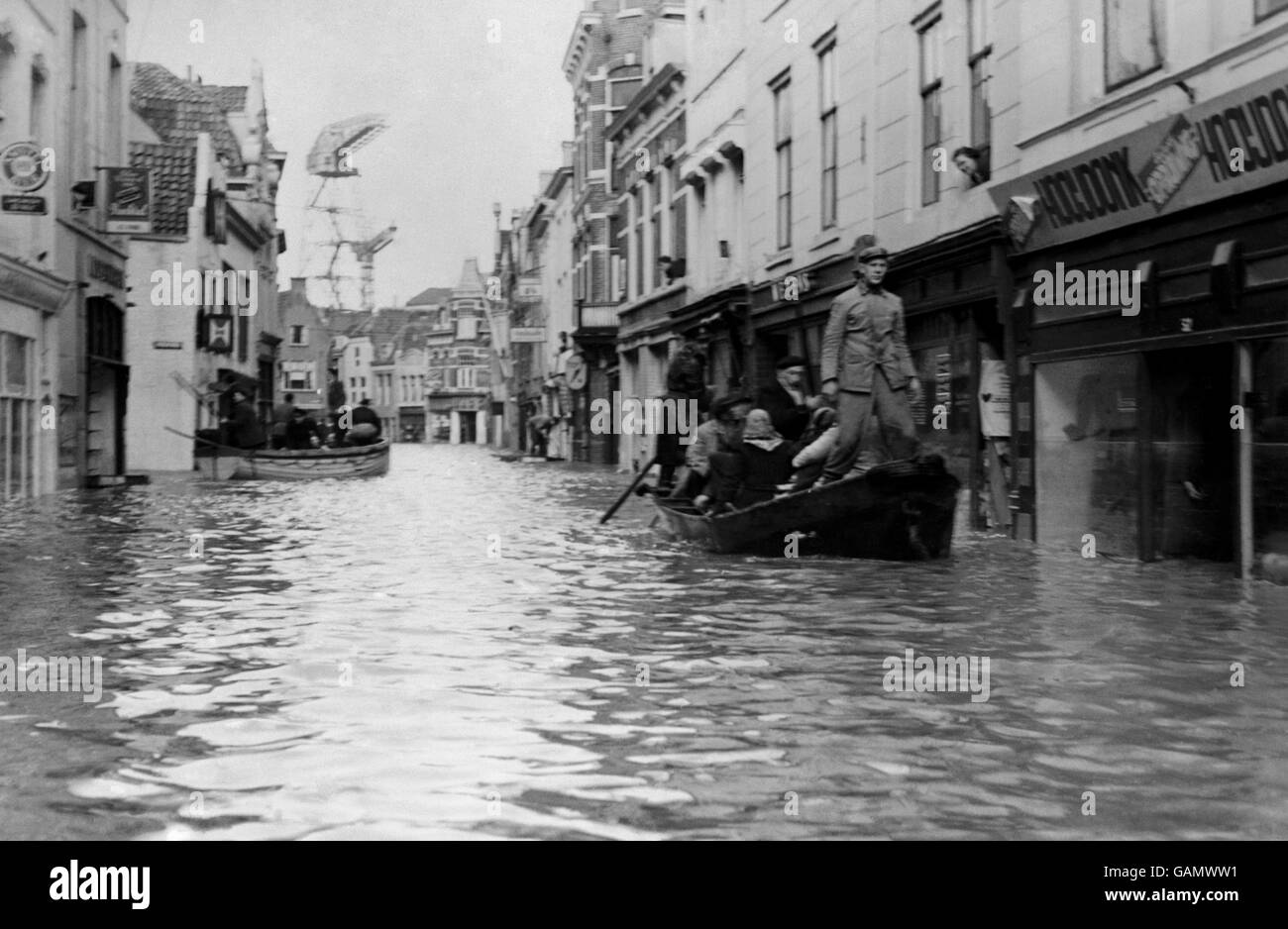 Small boats pass through what was once a busy shopping street in Flushing, Netherlands, carrying inhabitants who were rescued from their houses to safety. Stock Photo