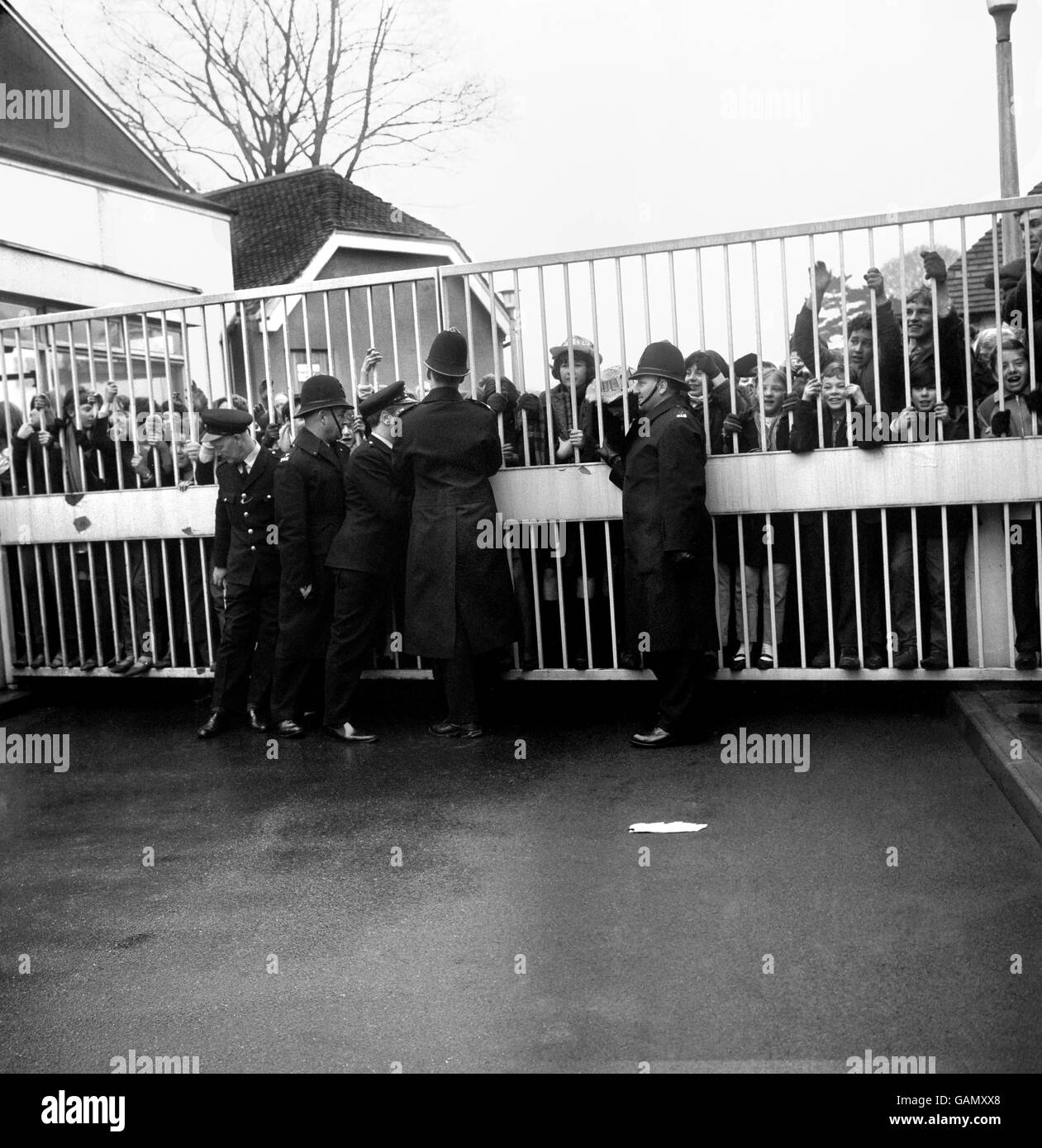 Police strain to keep the main gates closed against the pressure of Beatles fans, at ABC Television's studios at Teddington, Middlesex, where the group were taking part in all day recording sessions. Stock Photo