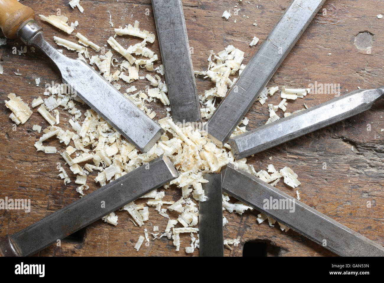 series of many sharp steel blades many chisels and sawdust chippings in