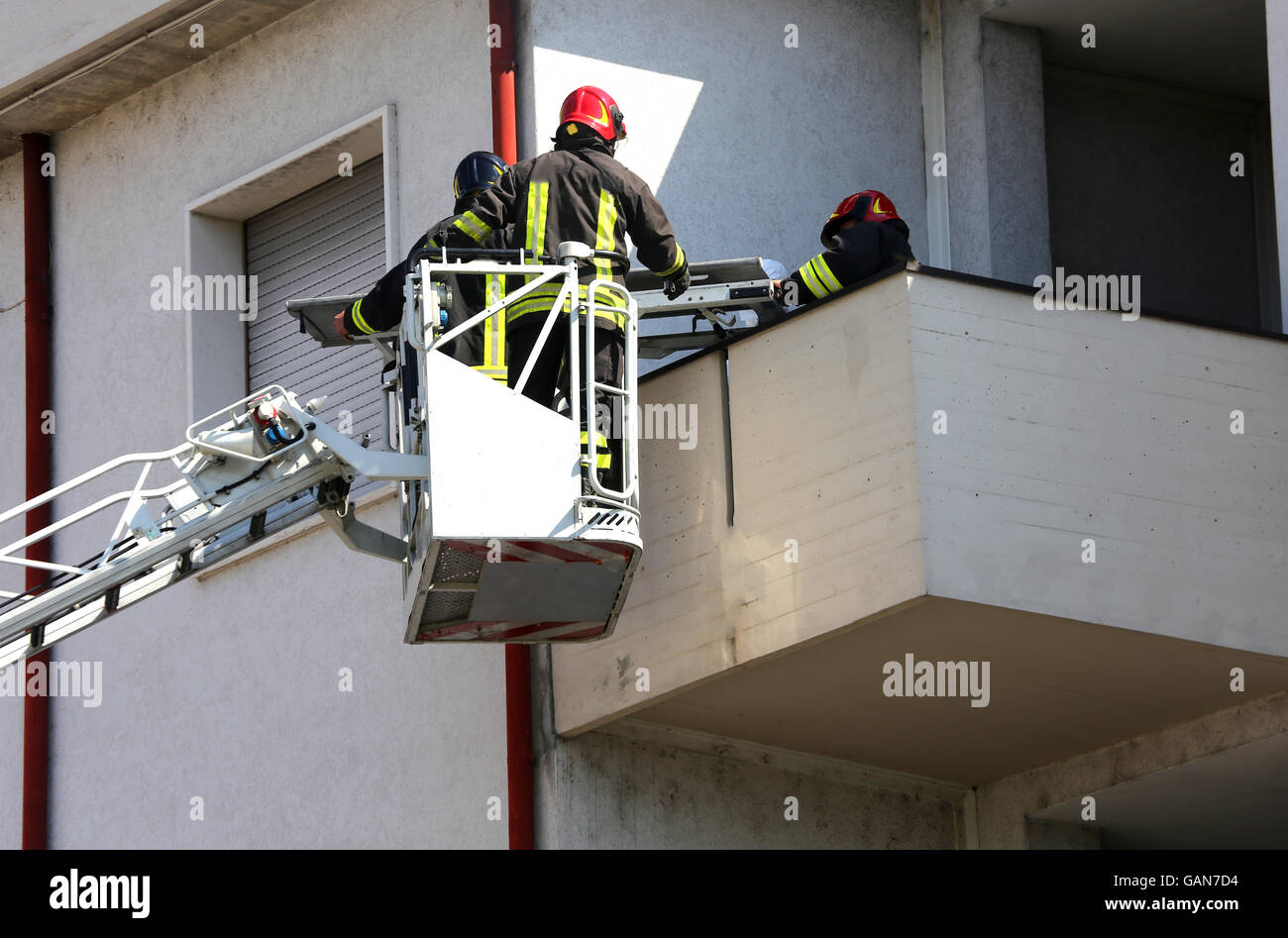 two firefighters in the elevated cage of fire truck Stock Photo