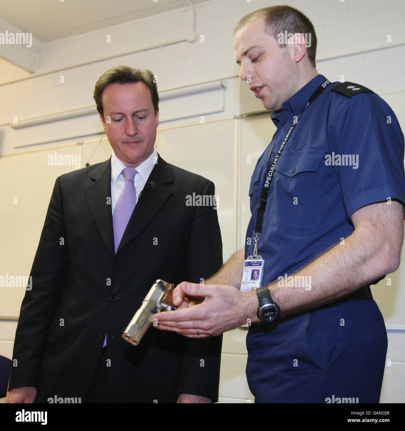 Conservative leader David Cameron (left) with firearms officer Matt Twist and a display of confiscated weapons during a visit to Lambeth Support Headquarters, south London. Stock Photo