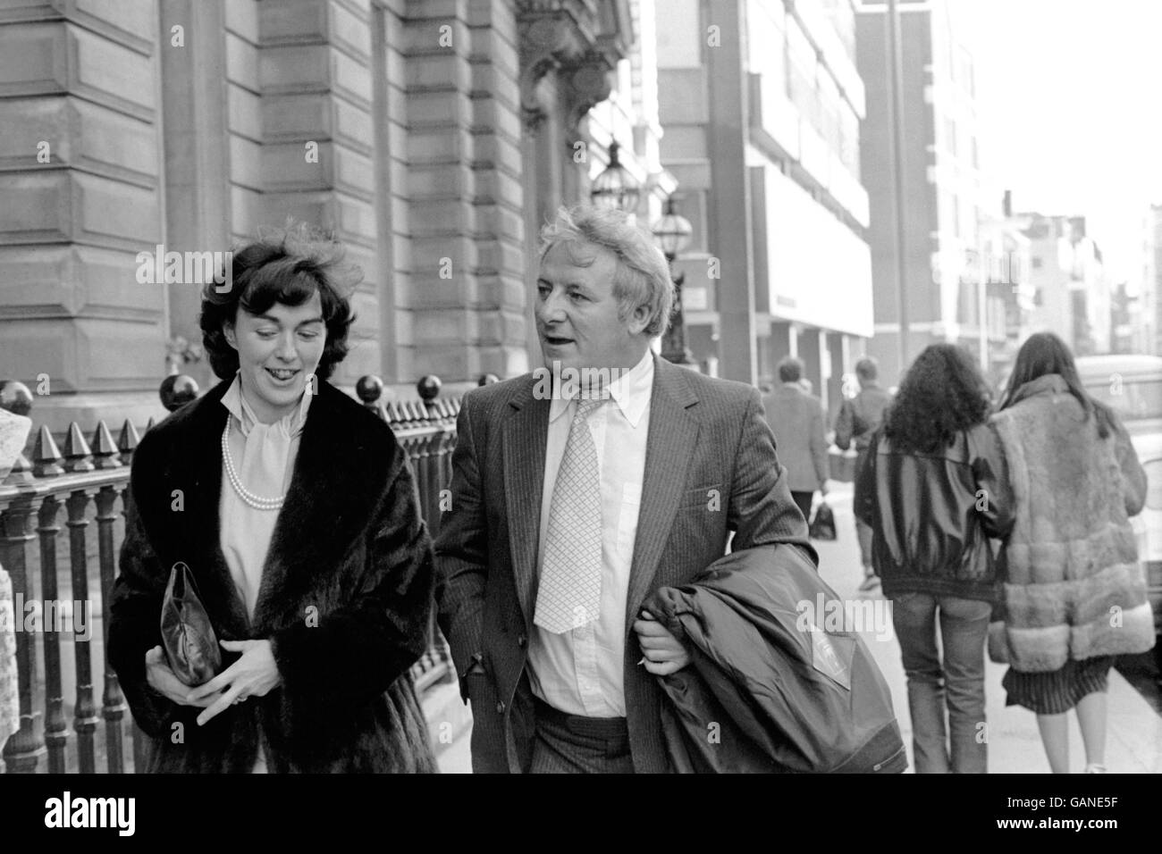 Former Queens Park Rangers and Manchester United manager Tommy Docherty (r) leaves court with his partner Mary Brown (l) after being charged with perjury Stock Photo