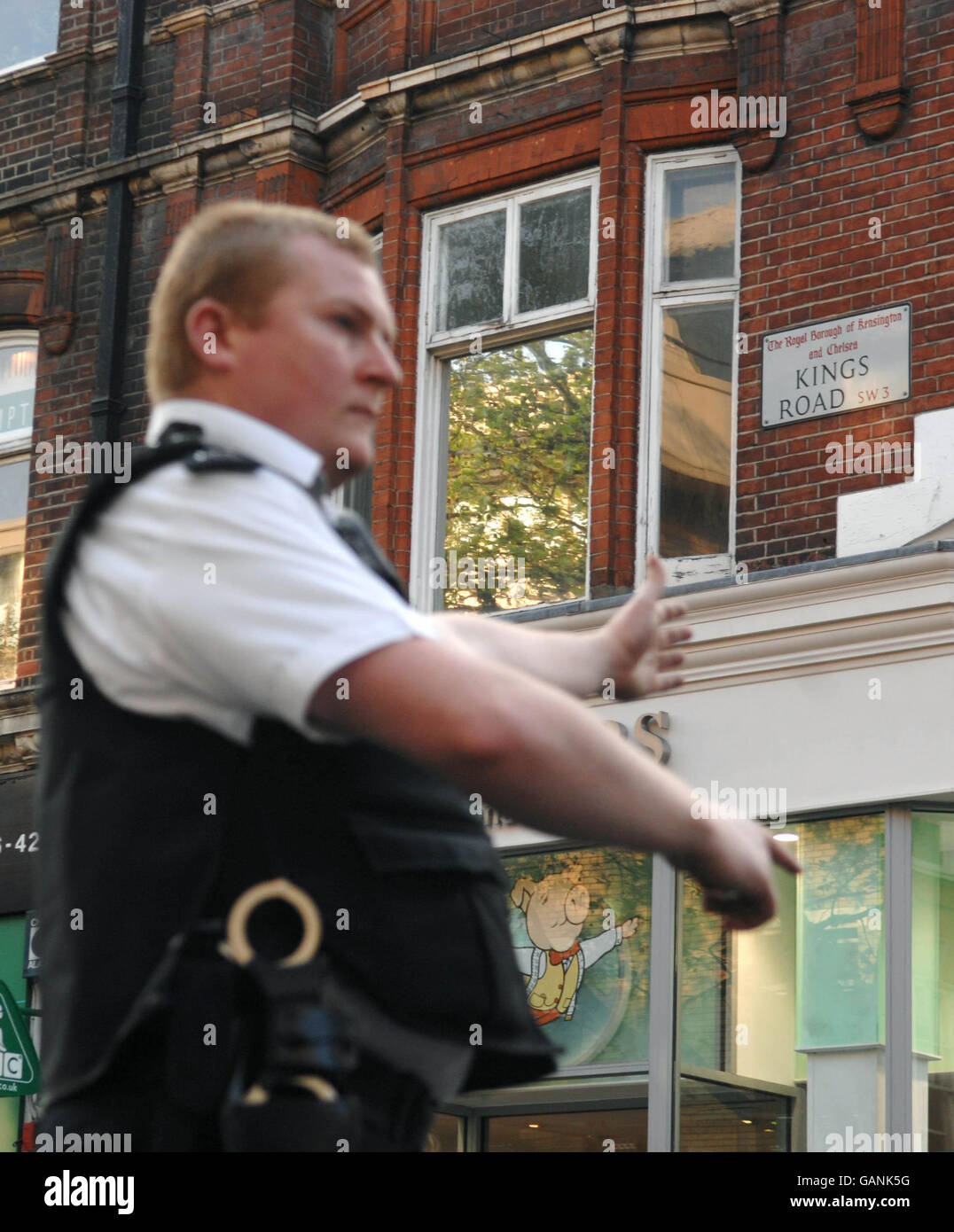 A police officer diverts traffic from the King's Road in central London, following an incident nearby, where armed police were shot at. Stock Photo