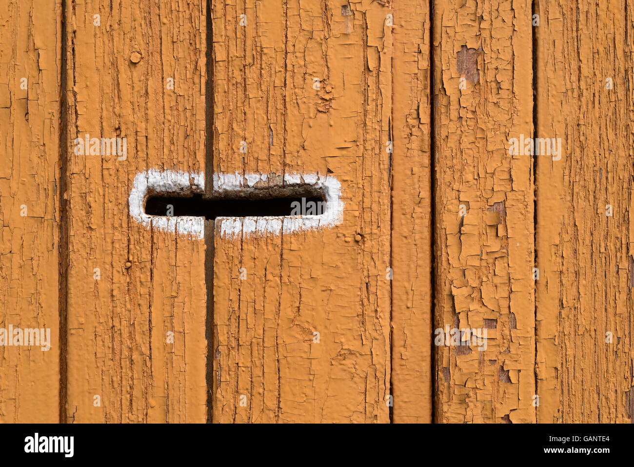 Single improvised letter box on a dark orange wooden fence Stock Photo