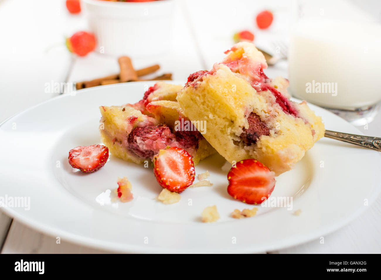 Tradittional czech dessert  pie with strawberries and glass of milk on white wood table Stock Photo