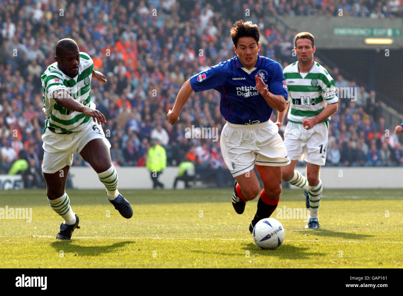 Rangers' Michael Mols (c) goes past Celtic's Paul Lambert (r) and ...