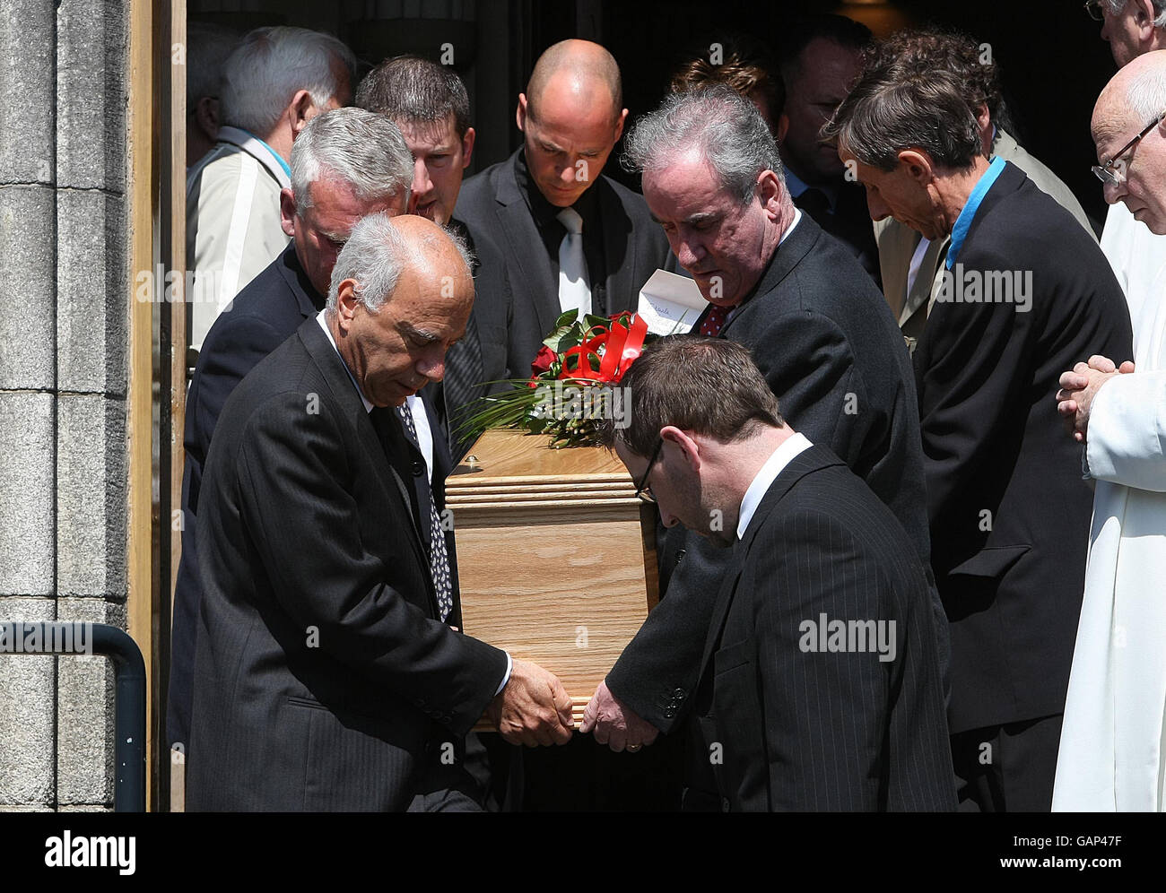 The partner of Nuala O'Faolain, John LowBeer (left) and mourners carry