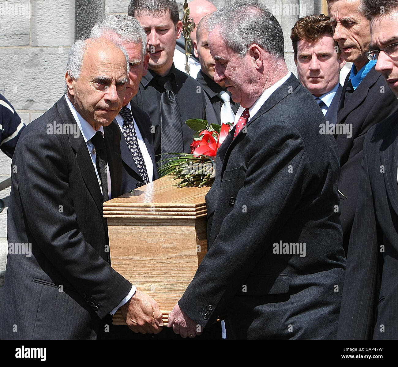 The partner of Nuala O'Faolain, John LowBeer (left) and mourners carry