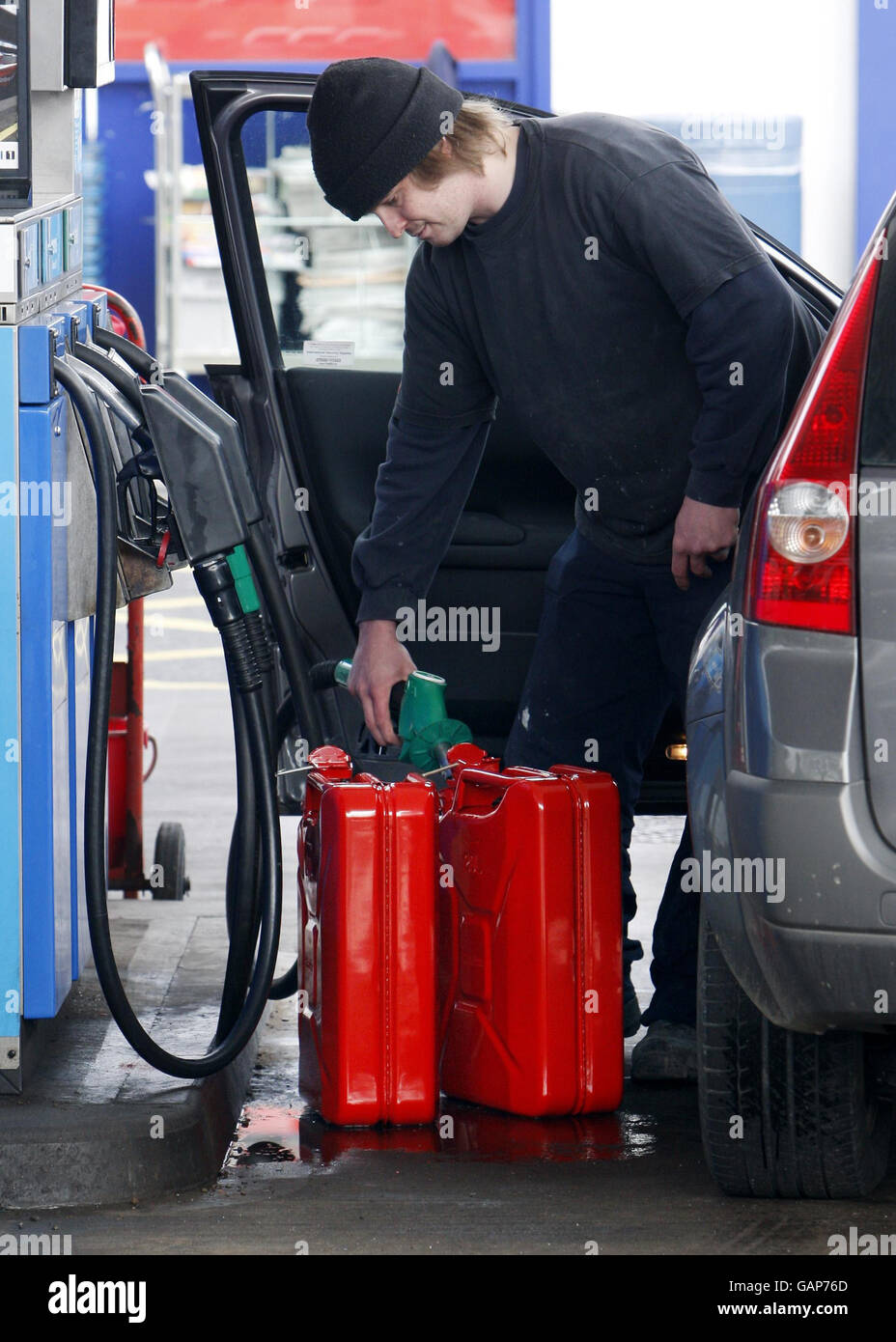 A man fills up jerry cans at the Esso petrol station on Willowbrae Road in Edinburgh Stock Photo