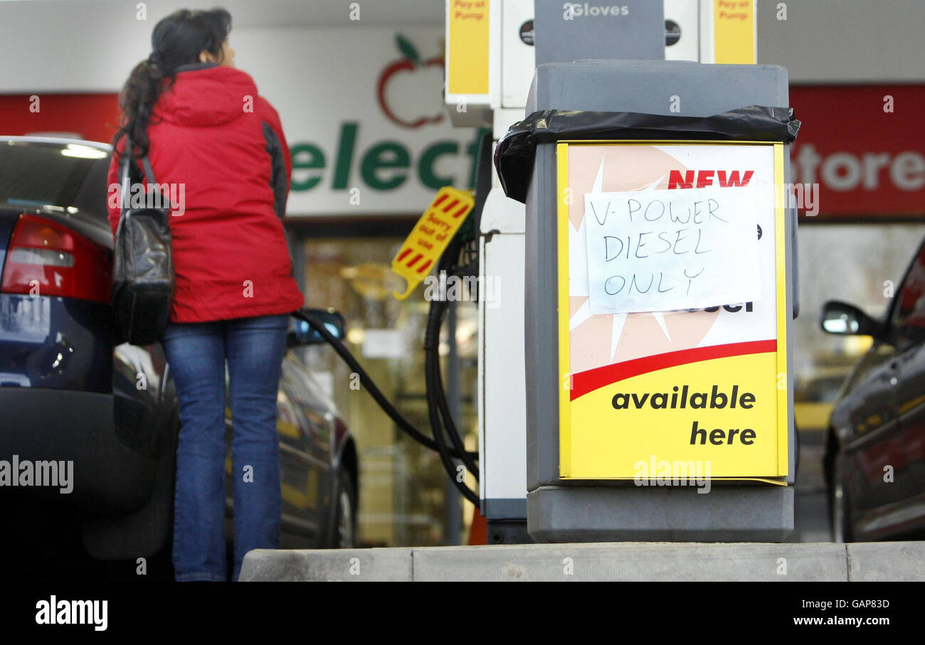 A general view of a petrol pump and a woman re-fuelling her car at a Shell garage on Ferry Road in Edinburgh. Stock Photo