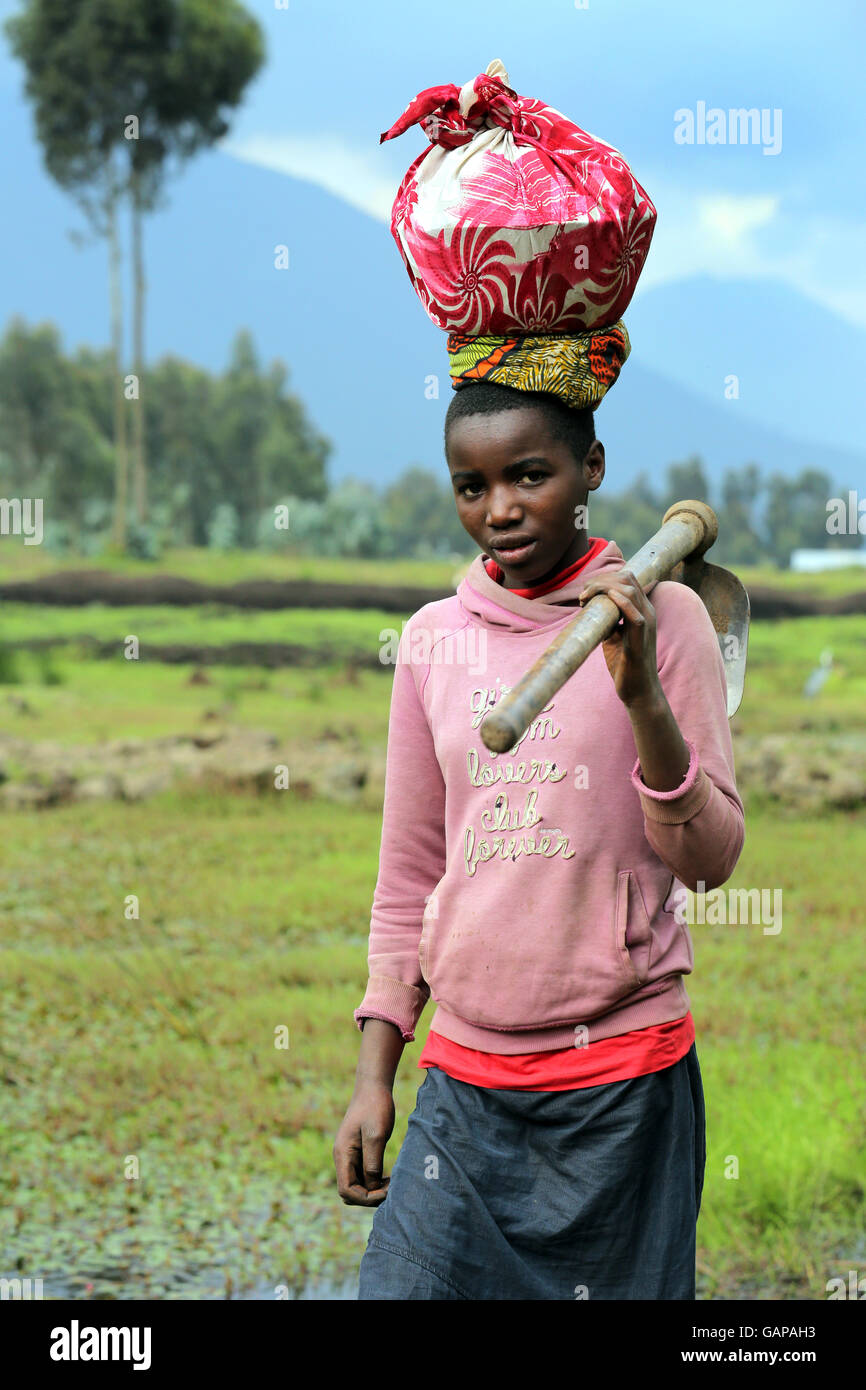 female farmworkers come home from field work in the volcanic landscape in Ruhengeri, Rwanda, Africa Stock Photo
