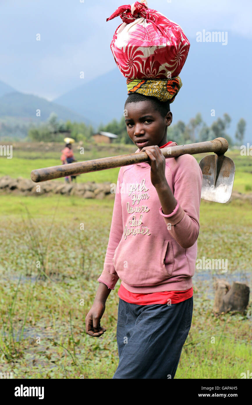 female farmworkers come home from field work in the volcanic landscape in Ruhengeri, Rwanda, Africa Stock Photo
