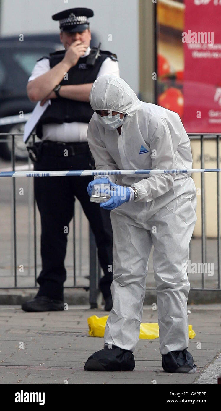 Police forensics officers at the scene where a teenage boy was murdered