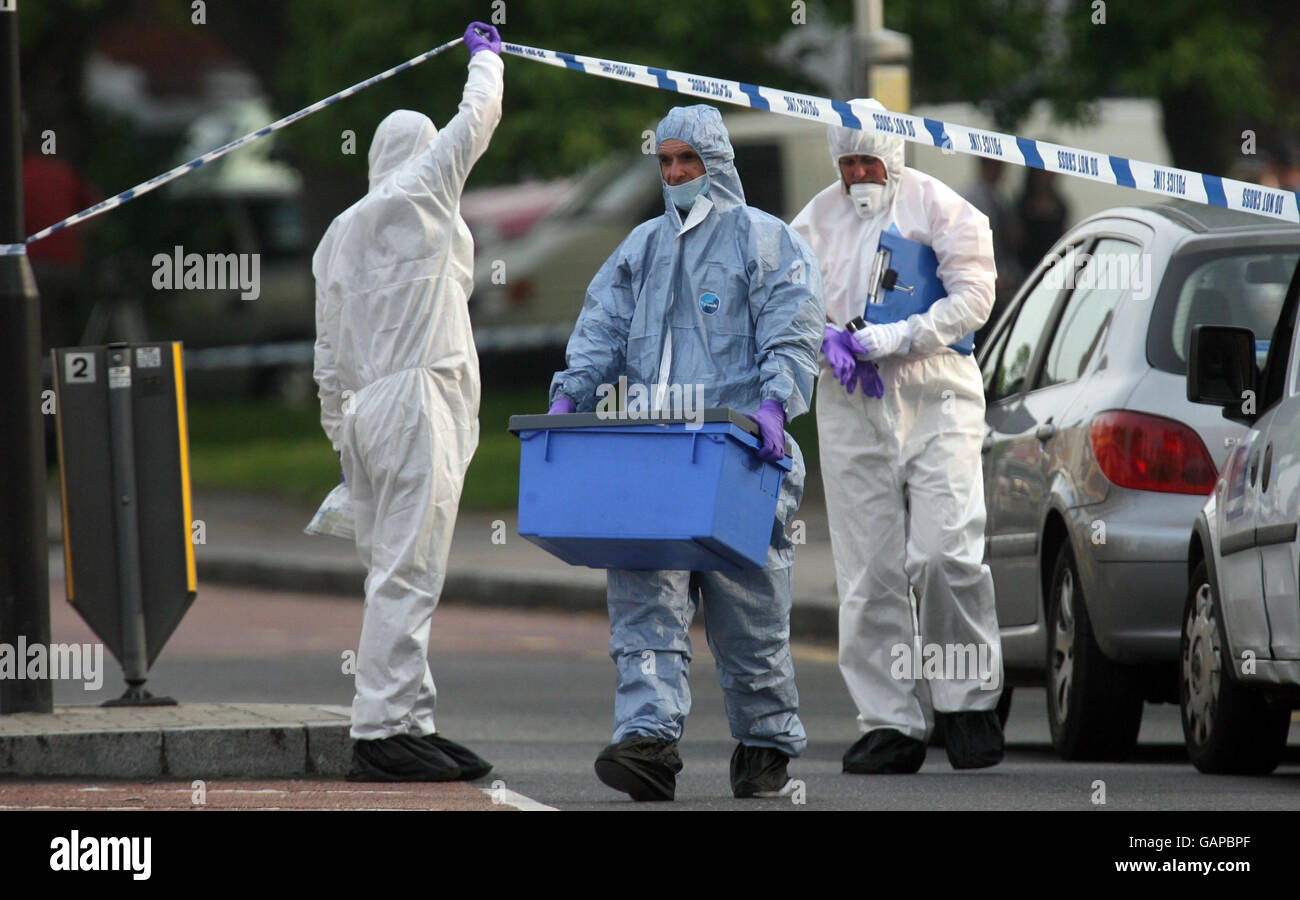 Police forensics officers at the scene where a teenage boy was murdered