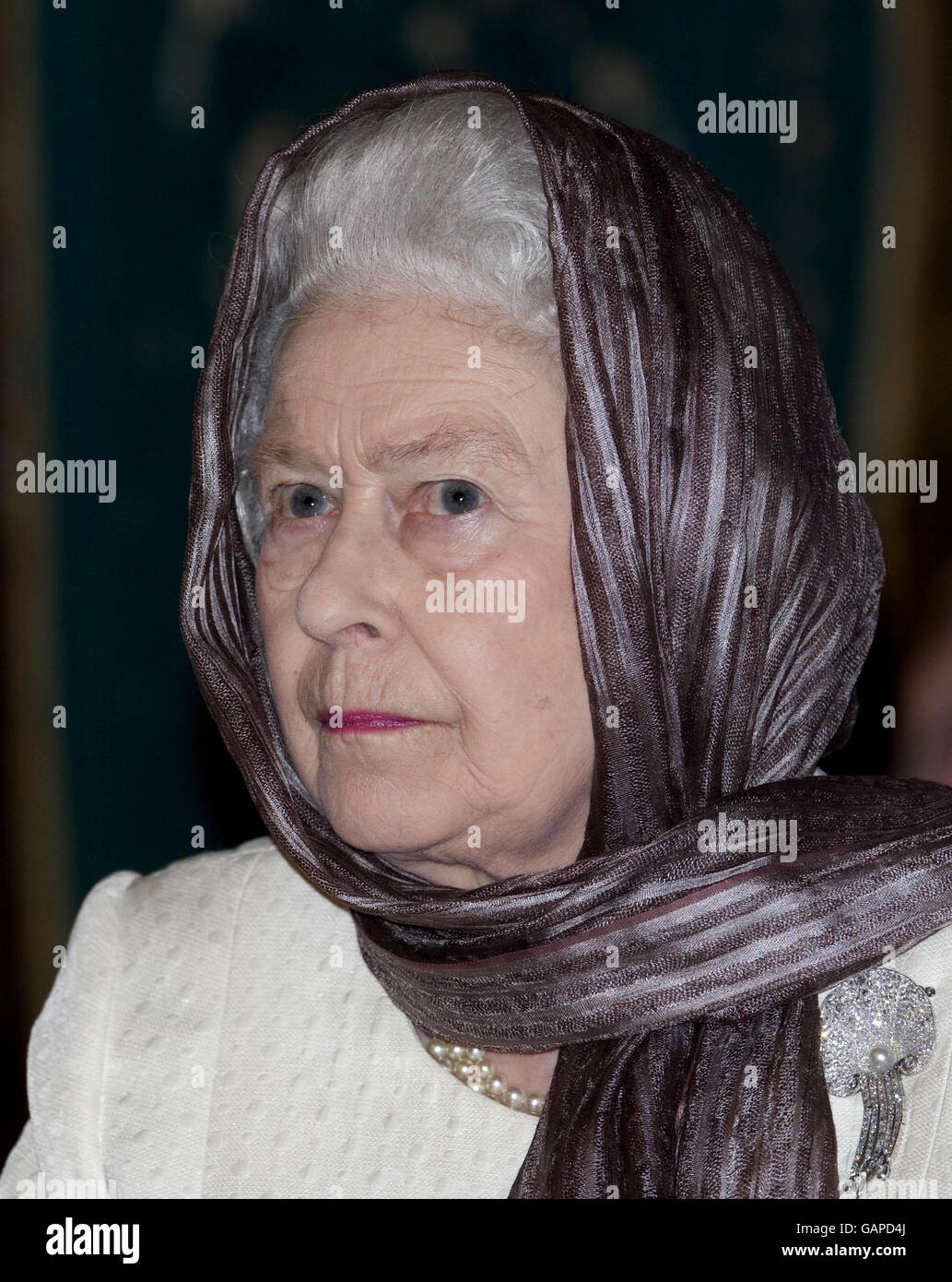 Queen Elizabeth II wears a head scarf during a visit the Green Mosque