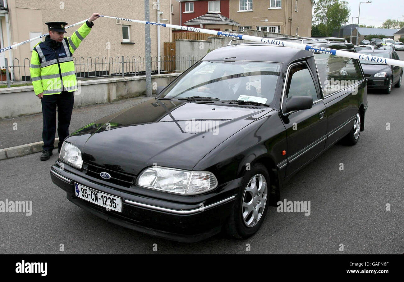 The body of a man in his 30s who has been murdered, is removed from the Kilconny Estate in the small border town of Belturbet, Co Cavan today. Stock Photo