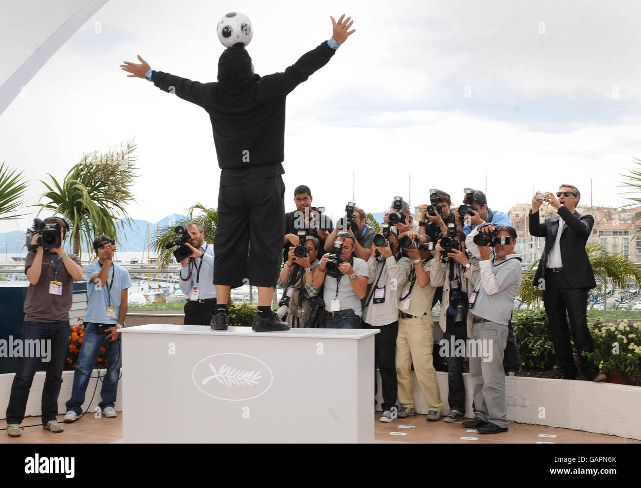 AP OUT. Maradona juggles a football in front of photographers as he attends a photocall for the film 'Maradona' by Emir Kusturica during the 61st Cannes Film Festival in France. Stock Photo