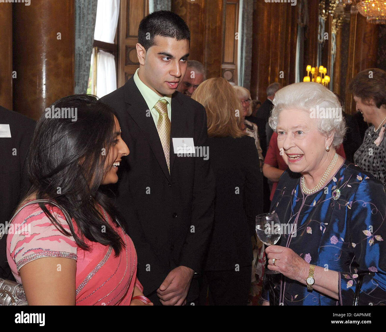 Britain's Queen Elizabeth II talks to Miss Anisha Raithatha and Kris ...