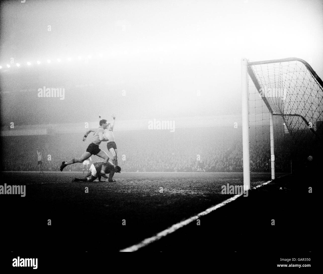 Wolverhampton Wanderers' Ray Crawford (l) and Alan Hinton (r) celebrate as the ball hits the Arsenal net for their team's only goal of the game, beating Arsenal goalkeeper Jim Furnell (on floor) Stock Photo