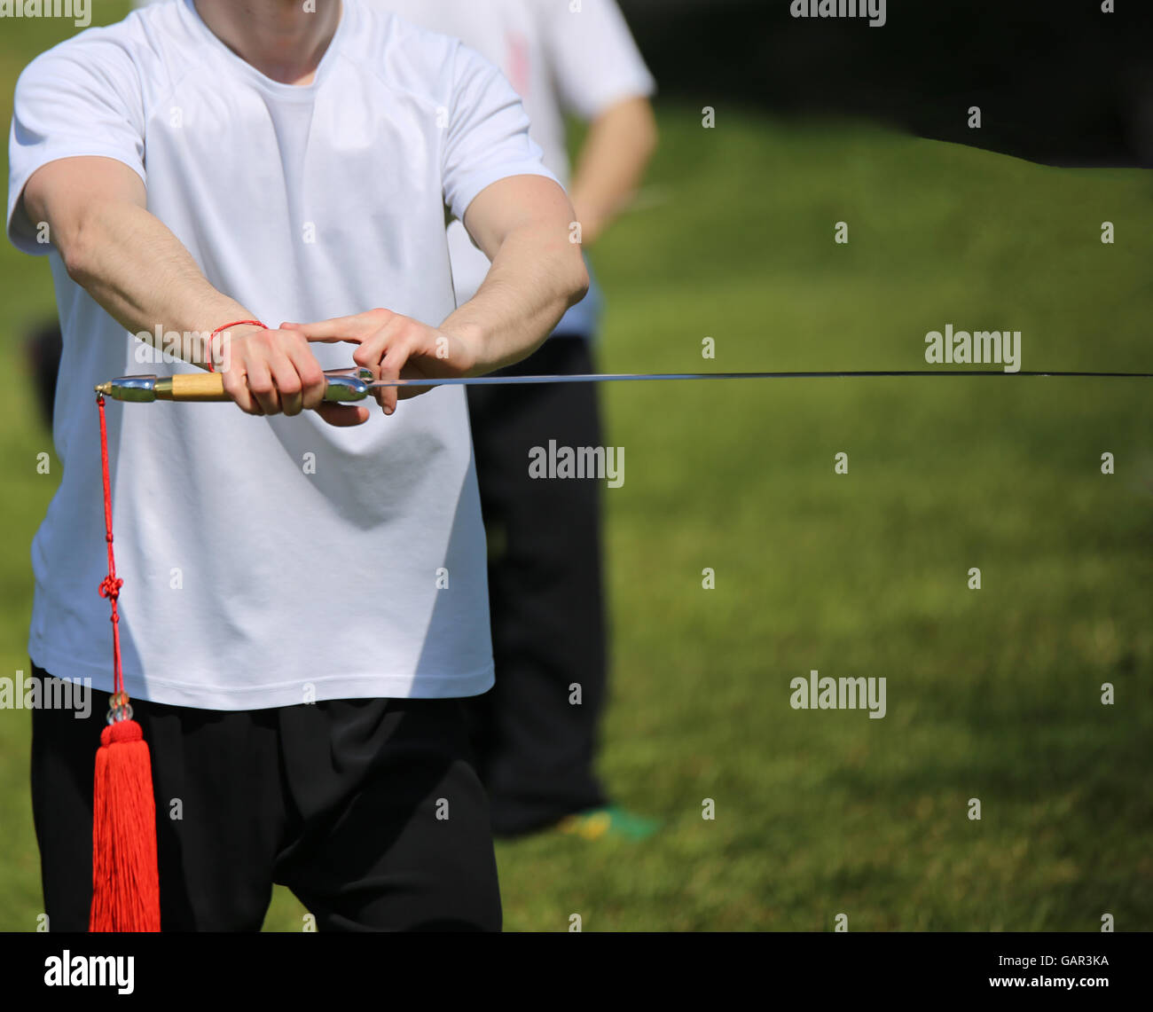 Tai Chi martial arts athlete expert makes motions with sharp sword