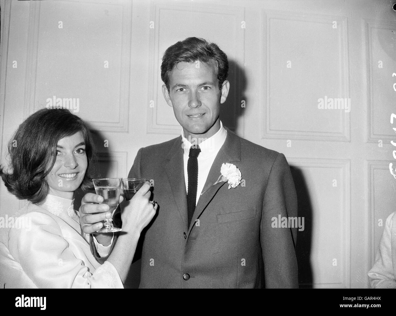 (L-R) Tennis players Jean Forbes and Cliff Drysdale toast their future happiness after taking time out from the Wimbledon Championships to marry each other Stock Photo