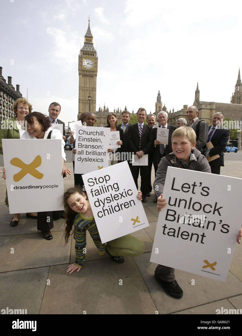 Campaigners in Parliament Square (including MPs from all political parties), Xtraordinary People charity founder Kate Griggs (background centre), and Southwark schoolchildren with dyslexia; Cara Abraham (front), Lenny Zvinoria (behind) and Cameron Simson (right) in front of Parliament in central London, before delivering an 'end of school term report' to Downing Street urging them to fast-track their support for dyslexic children and their families following a series of damning reports from dyslexia charity Xtraordinary People. Stock Photo