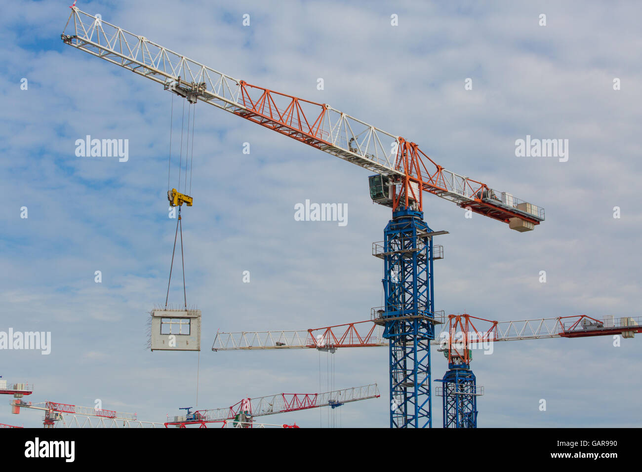 Tower cranes lifting and shifting the precast fabrication block hanging in the air from one spot to another. Singapore. Stock Photo