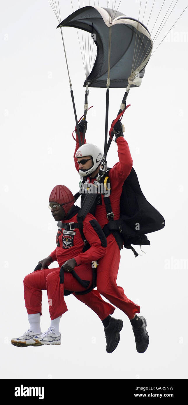 The Archbishop of York, Dr John Sentamu (left) takes part in a sponsored parachute jump, with a member of the Red Devils parachute display team over Langar Airfield in Nottinghamshire. Stock Photo