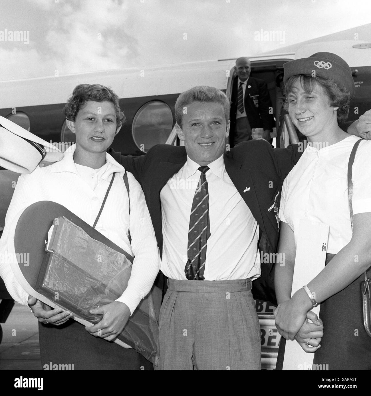 Brian Phelps, who earned a Bronze Olympic Medal for highboard diving, with fellow medalists Natalie Steward, left, who earned a silver for the 100m backstroke and bronze for 100m freestyle; and Anita Lonsbrough who won the 200m breaststroke gold medal, arriving back at Heathrow Airport. Stock Photo