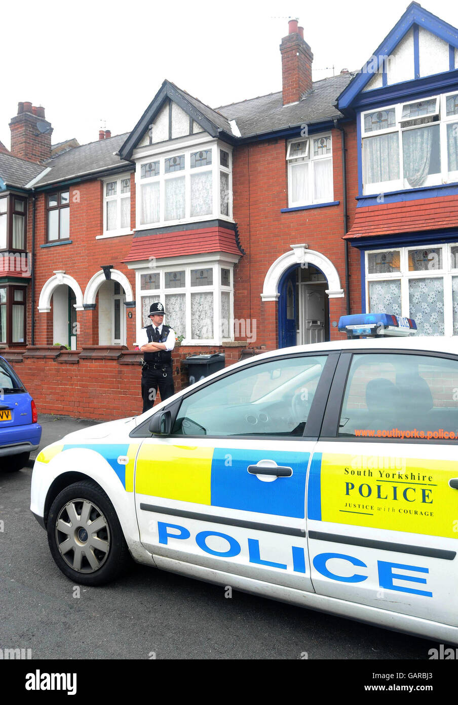 A police officer stands outside a house on Bainbridge Road, Balby, Doncaster, South Yorkshire where a 19-year-old man was stabbed. Stock Photo
