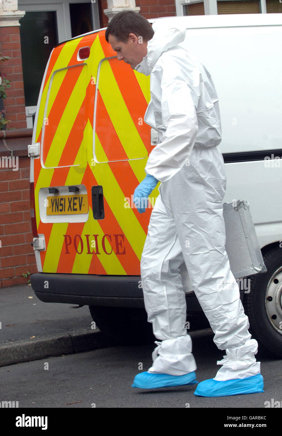 A Scenes of Crime Officer prepares to enter a house on Bainbridge Road, Balby, Doncaster, South Yorkshire where a 19-year-old man was stabbed. Stock Photo