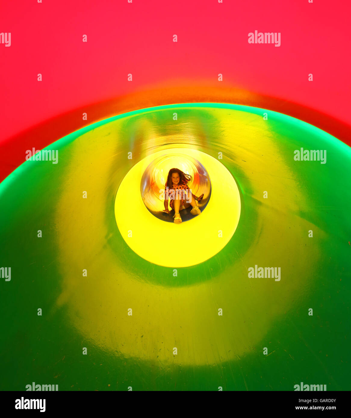 smiling little girl down the slide of a large playground Stock Photo ...