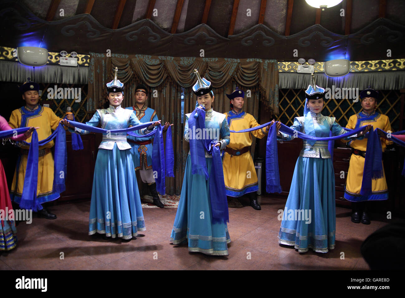Mongolian dancers and singers, men and women, wear Mongolian costumes and perform to guests at the 99 Mongolian Yurts Restaurant. Beijing, China. Stock Photo